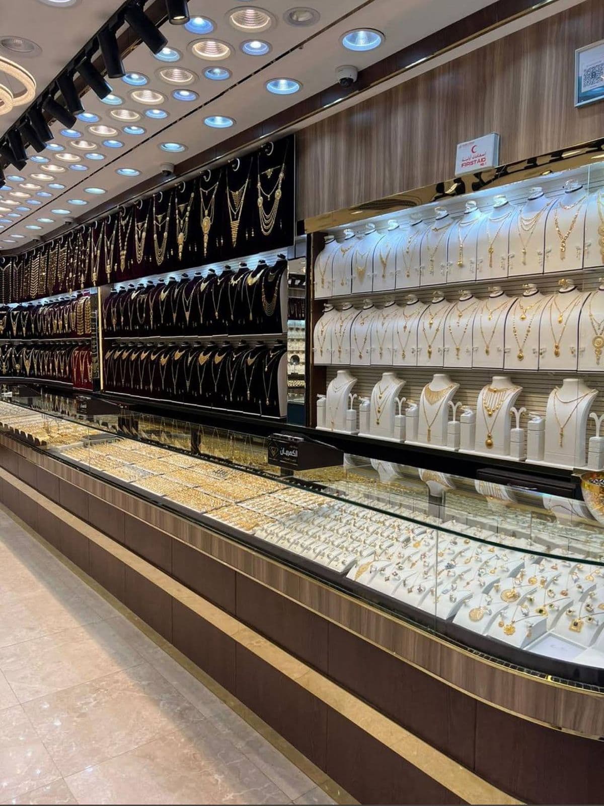 Gold shop jewellery display wall with lit glass counters
