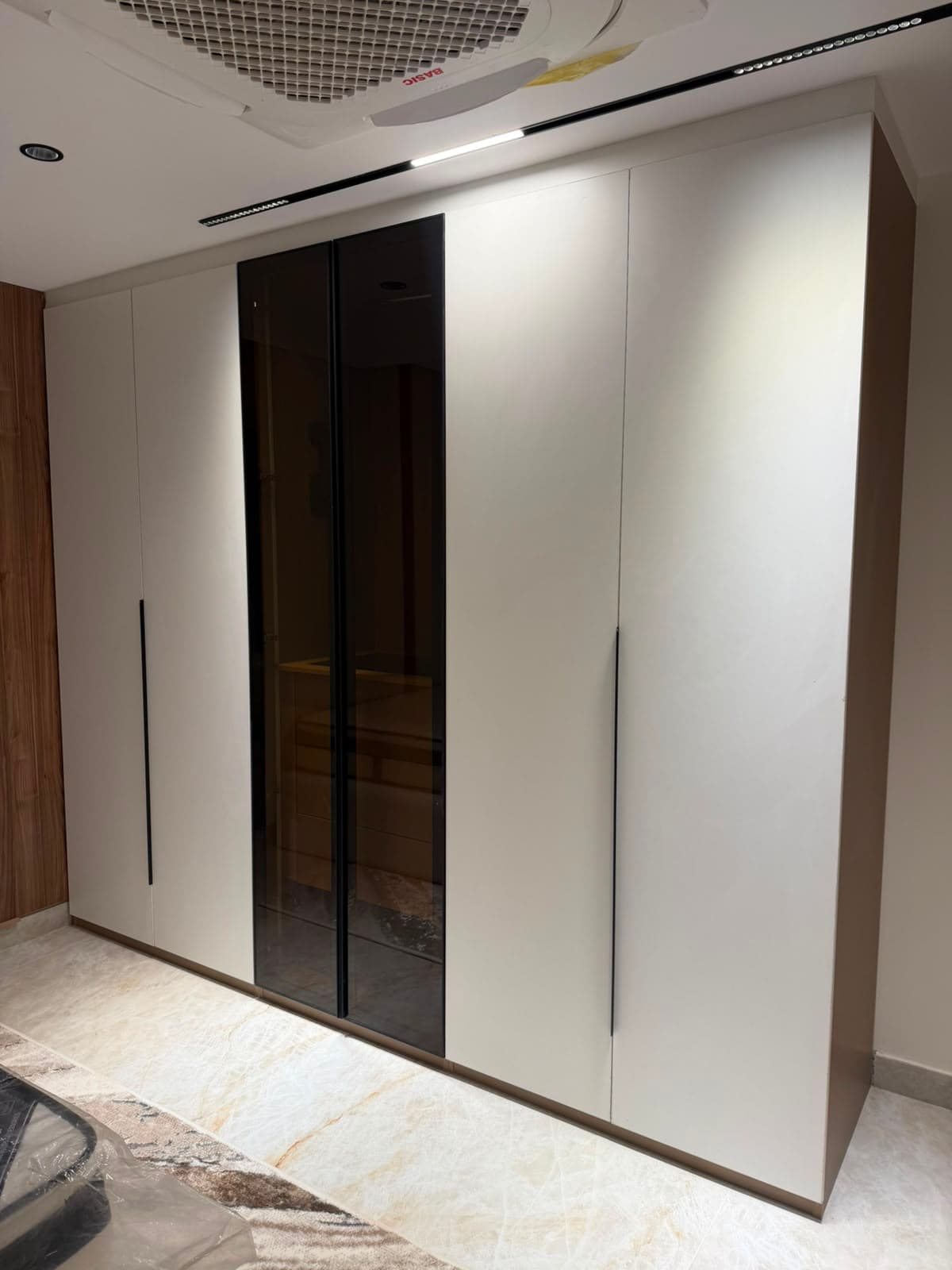 Fitted wardrobe with smoked glass mirror doors